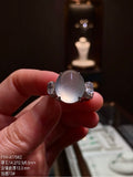 High-icy oval jadeite cabochon ring with diamond-accented 18K gold setting, front view