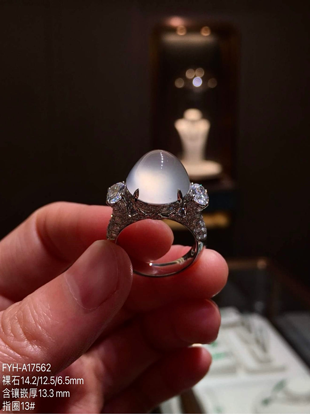 Front view of the oval jadeite cabochon ring showing its diamond-set shoulders