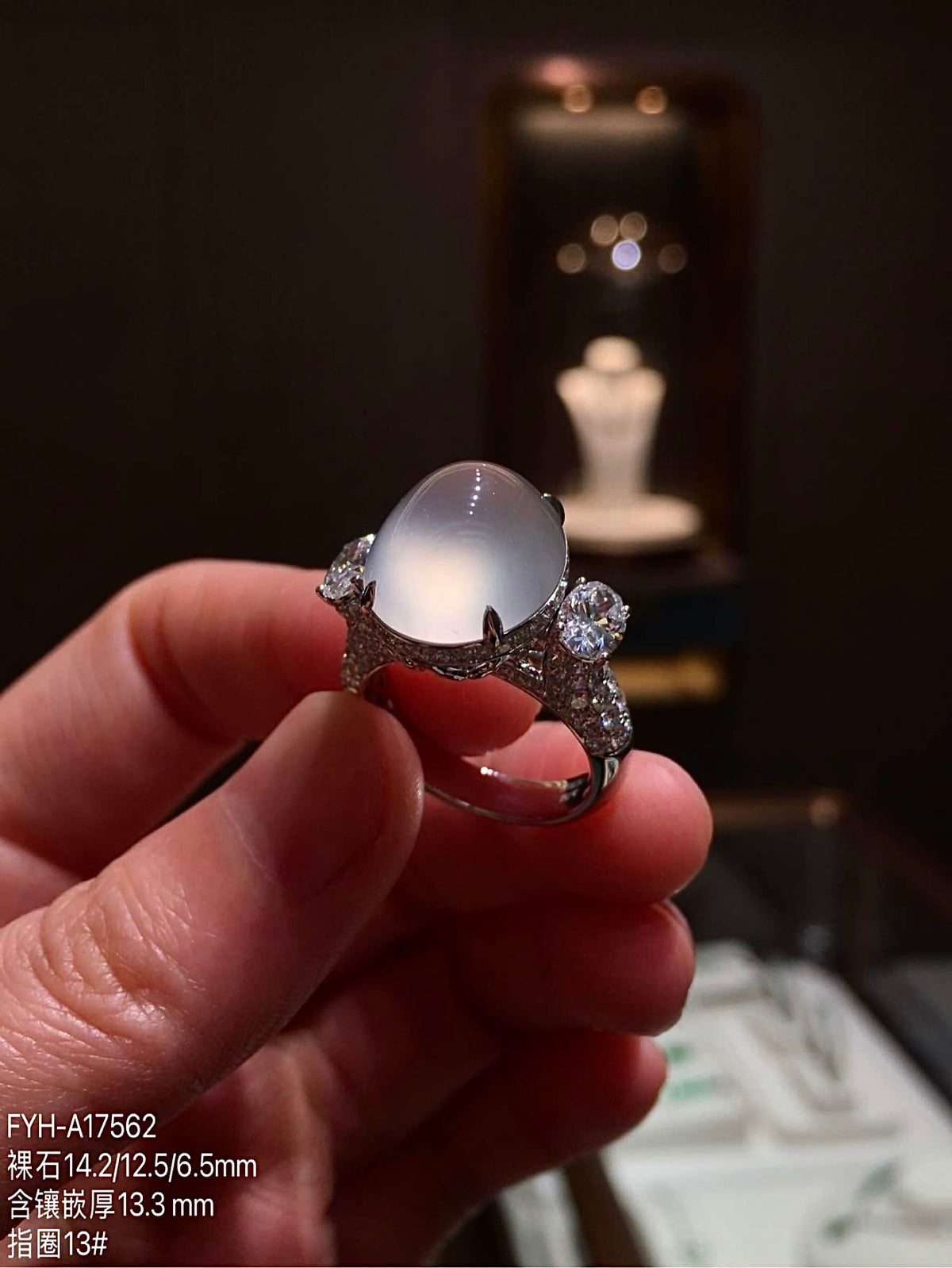 Oblique view of the oval jadeite ring showing the diamond-accented right shoulder
