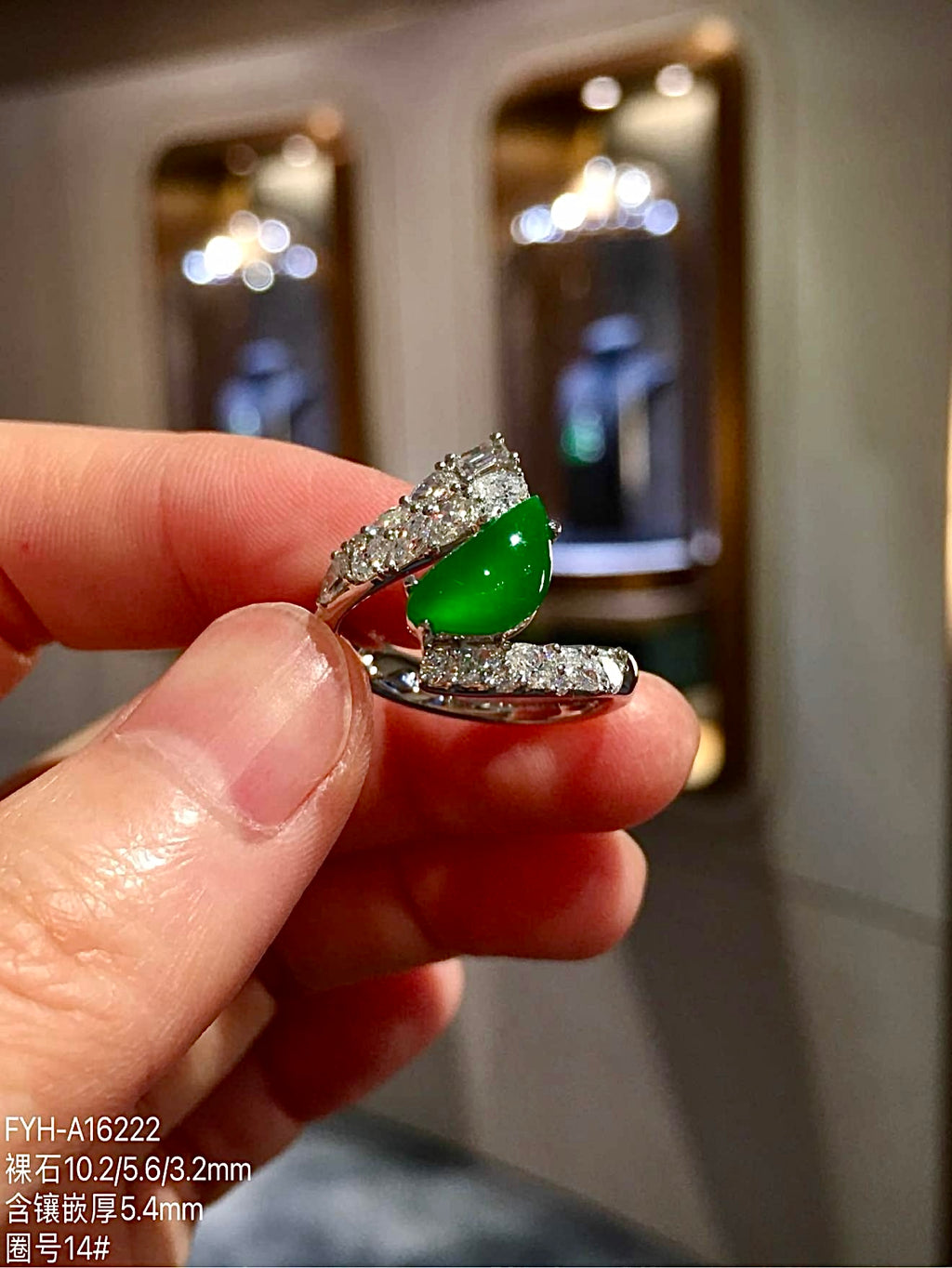 Side view of pear-shaped green jadeite ring in 18K gold with diamonds