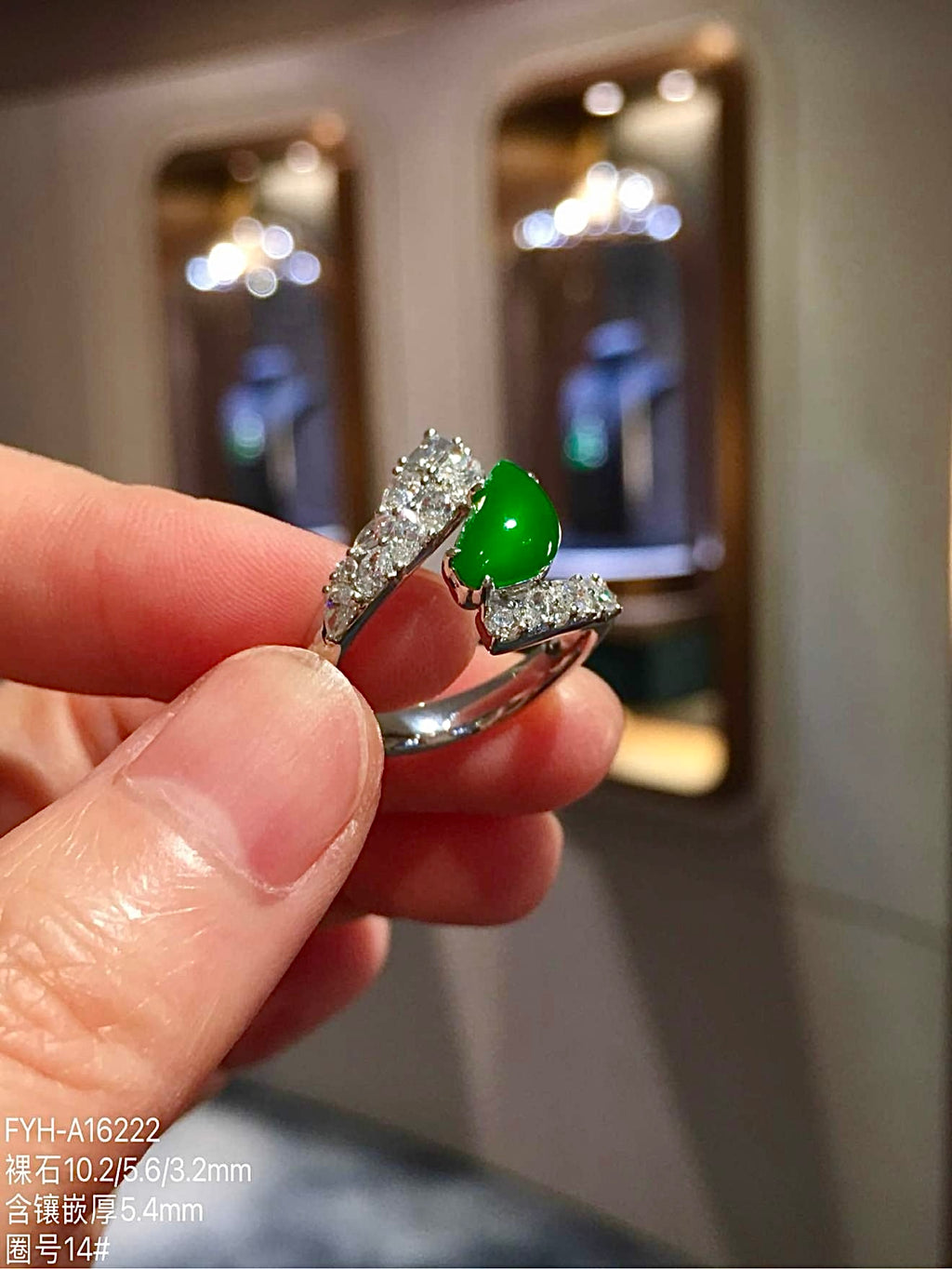 Three-quarter view of green jadeite ring and diamond-set sculptural shoulders