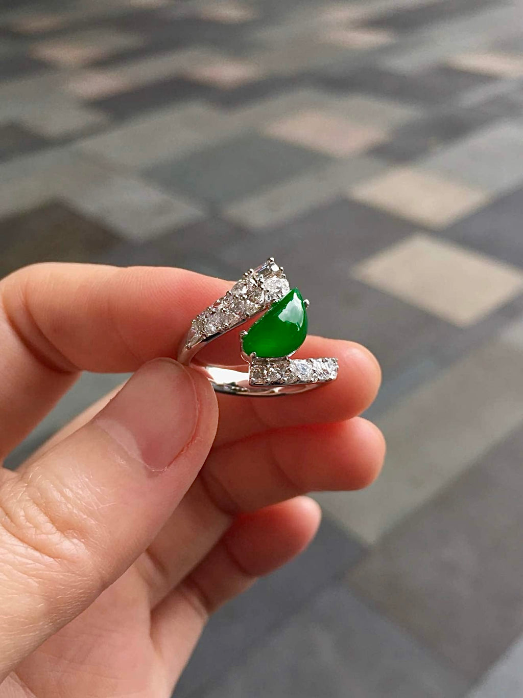 Green jadeite and diamond ring photographed outdoors in natural light