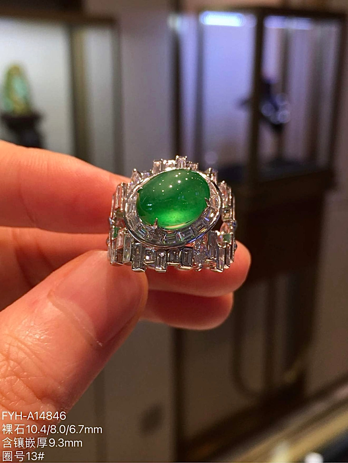 Close frontal view of oval yang green jadeite cabochon within a diamond-set ring