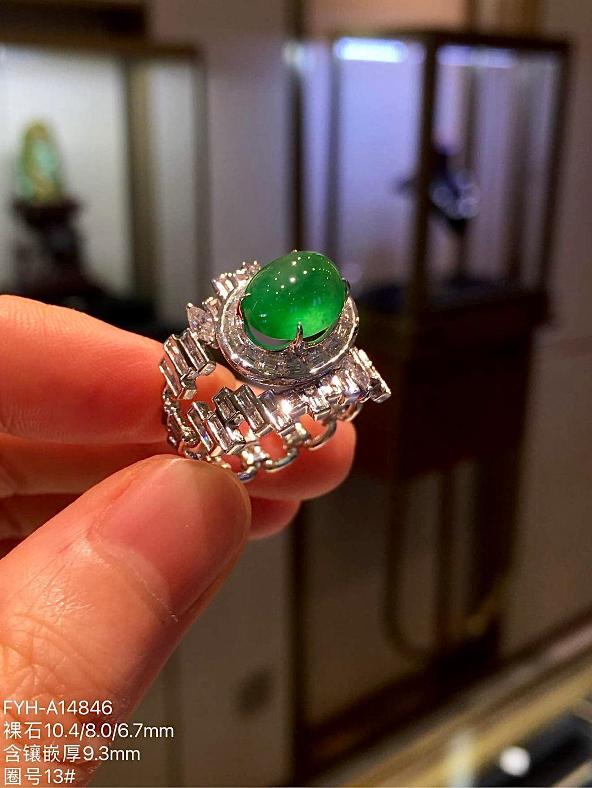 Oval yang green jadeite cabochon and geometric diamond setting, opposite angled view