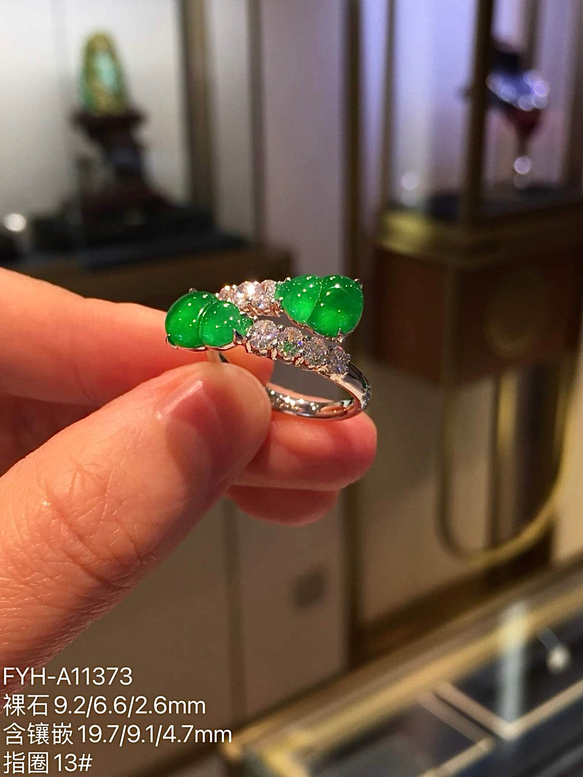 Close view of two carved yang green jadeite gourds framed by diamonds