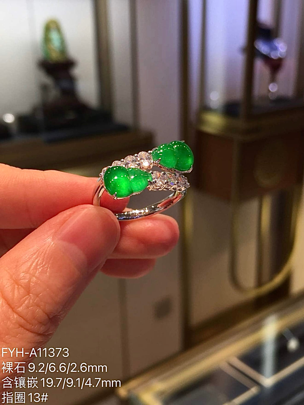 Side-angle view of the twin-gourd jadeite ring showing the open band