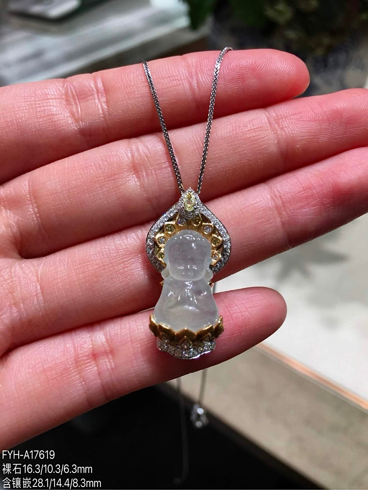 Jadeite Baby Buddha pendant shown against the hand for scale