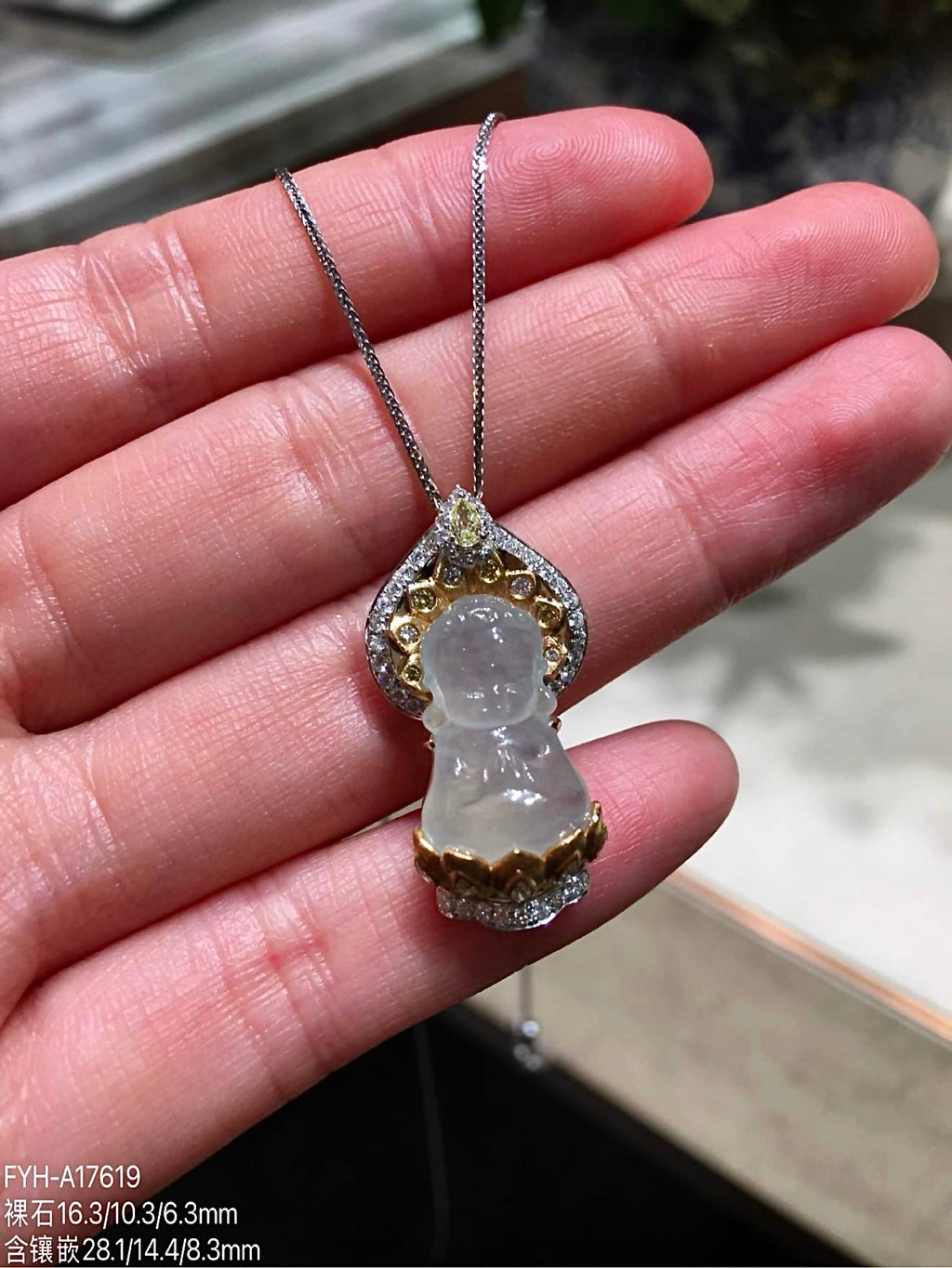 Front close view of carved jadeite Baby Buddha pendant with diamond setting