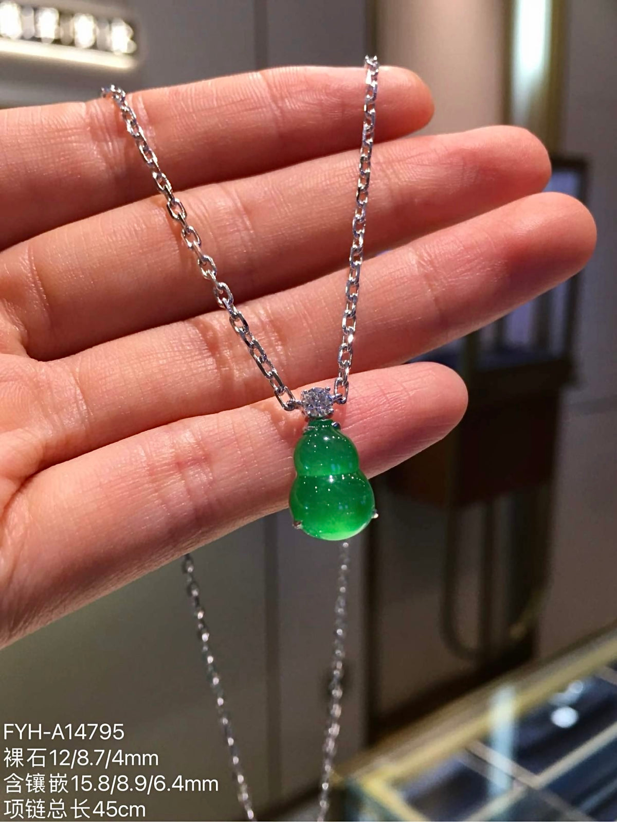 Closer front view of carved vivid green jadeite gourd and chain