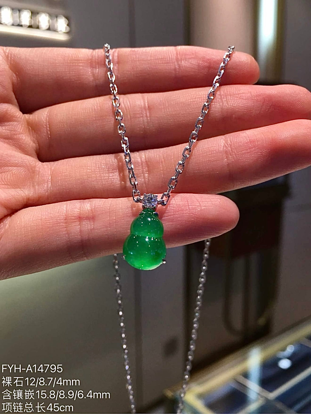 Front view of glass-type green jadeite gourd suspended from the included chain