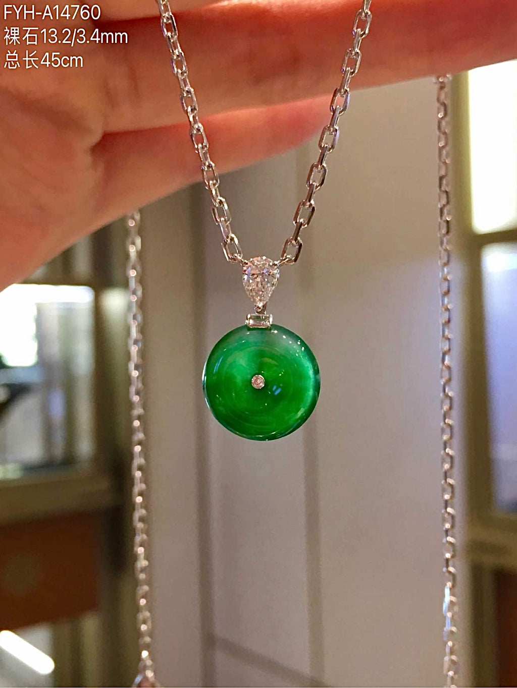 Angled view of glass-type jadeite Ping An Kou on its 45 cm chain