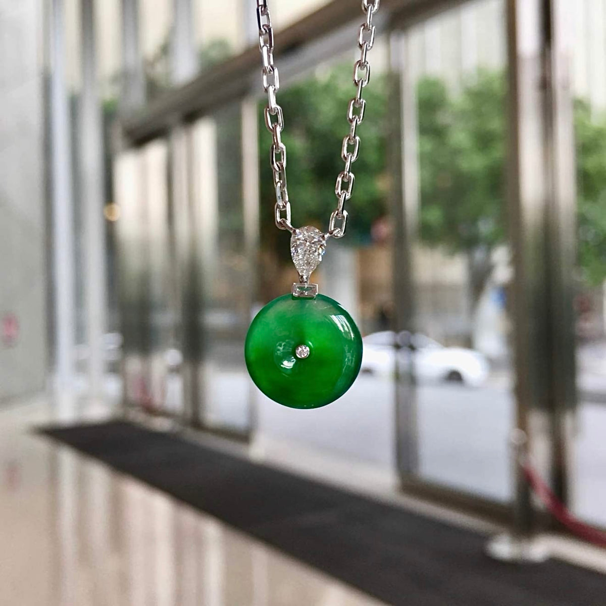 Natural-light view of jadeite Ping An Kou with floating green and linked chain