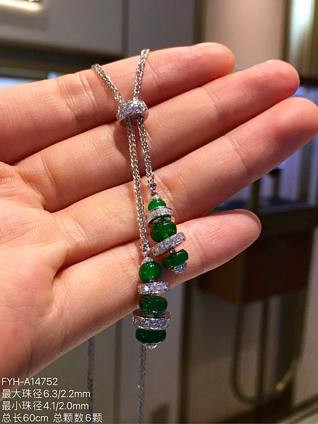 Two hanging strands of jadeite Lu Lu Tong beads beneath a diamond-set slider