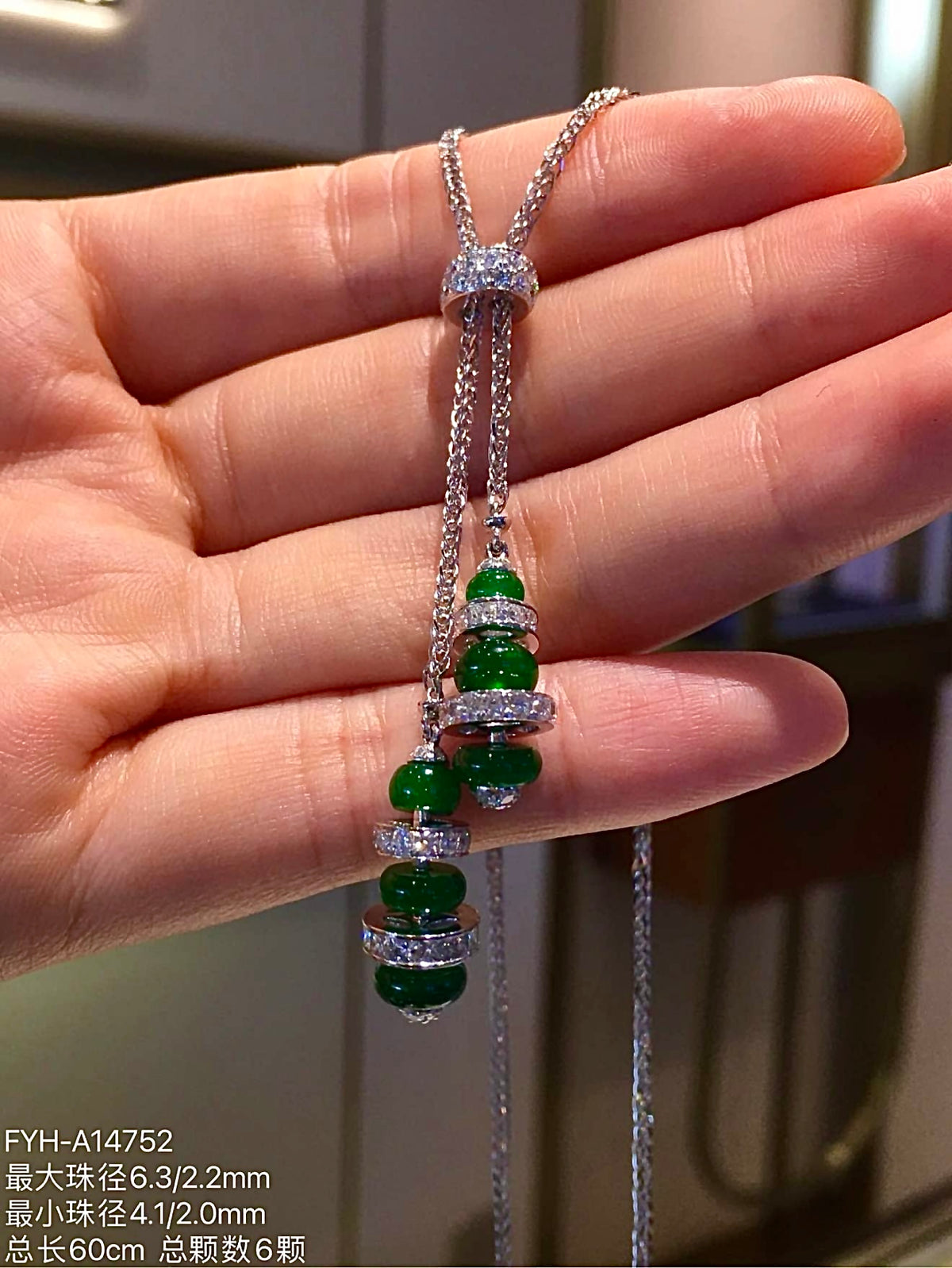 Angled view of six jadeite beads with 18K gold and diamond details