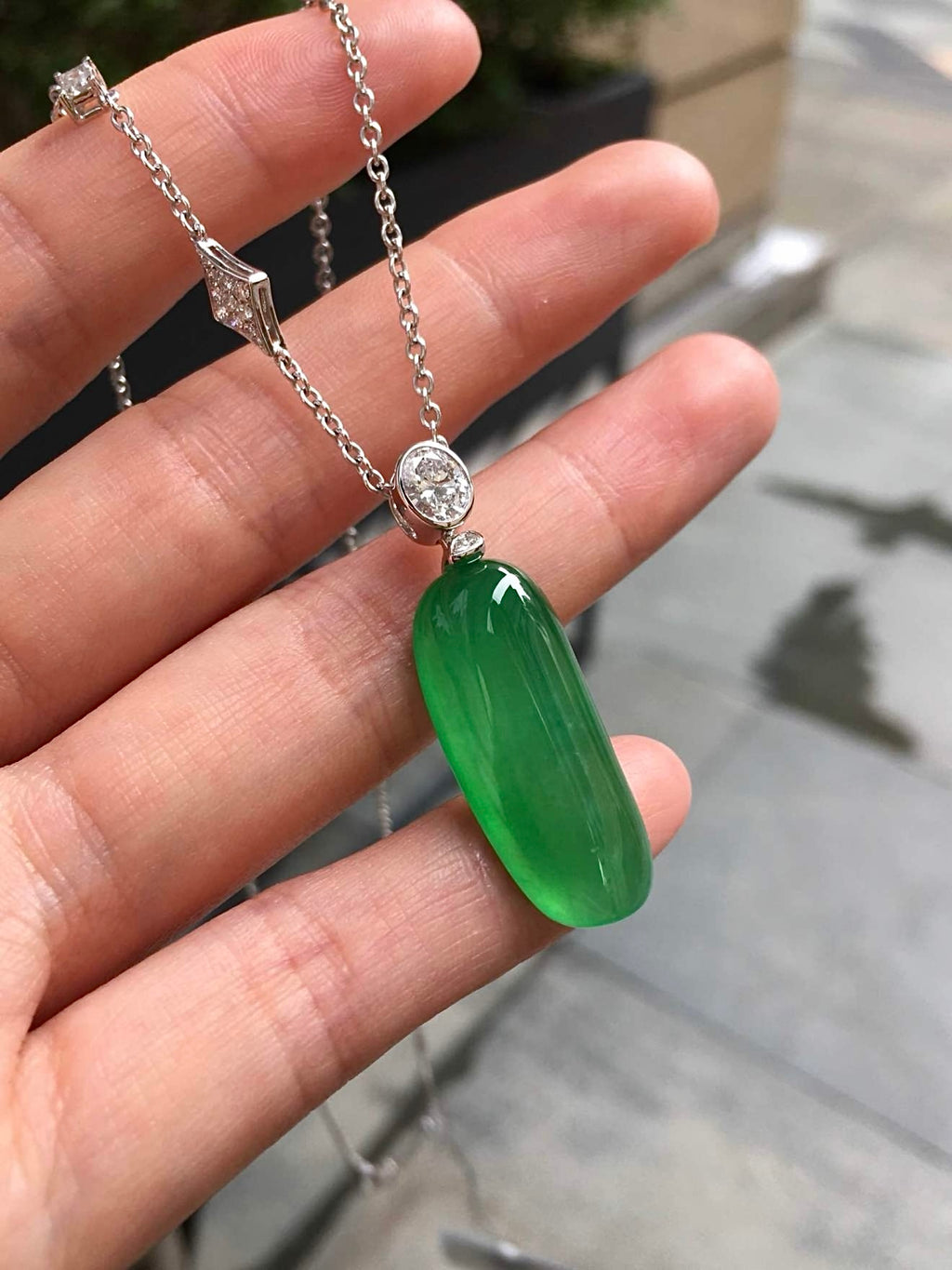 Outdoor view of green jadeite Fu Gua necklace in natural light