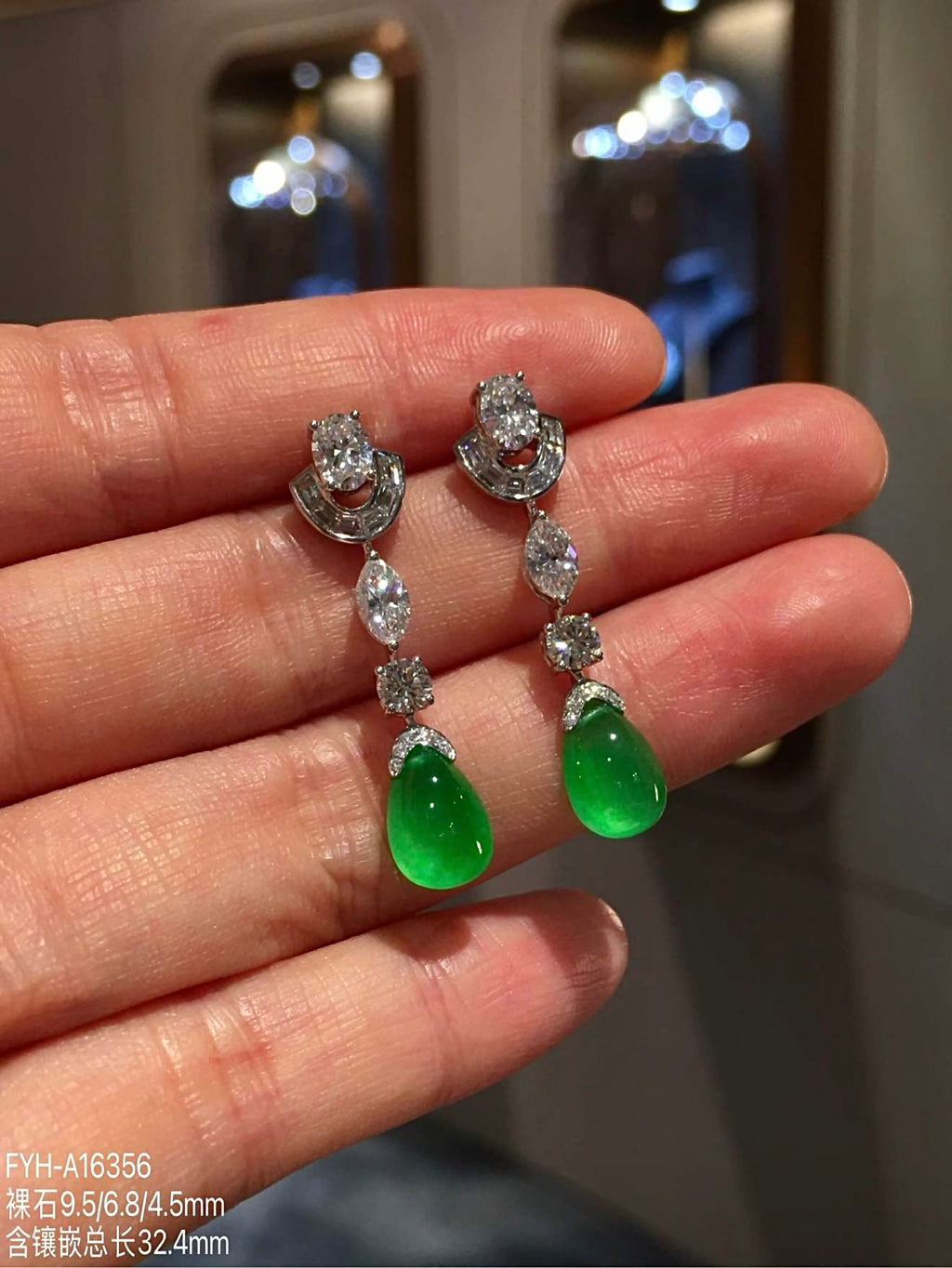 Angled view of polished green jadeite teardrops beneath diamond settings