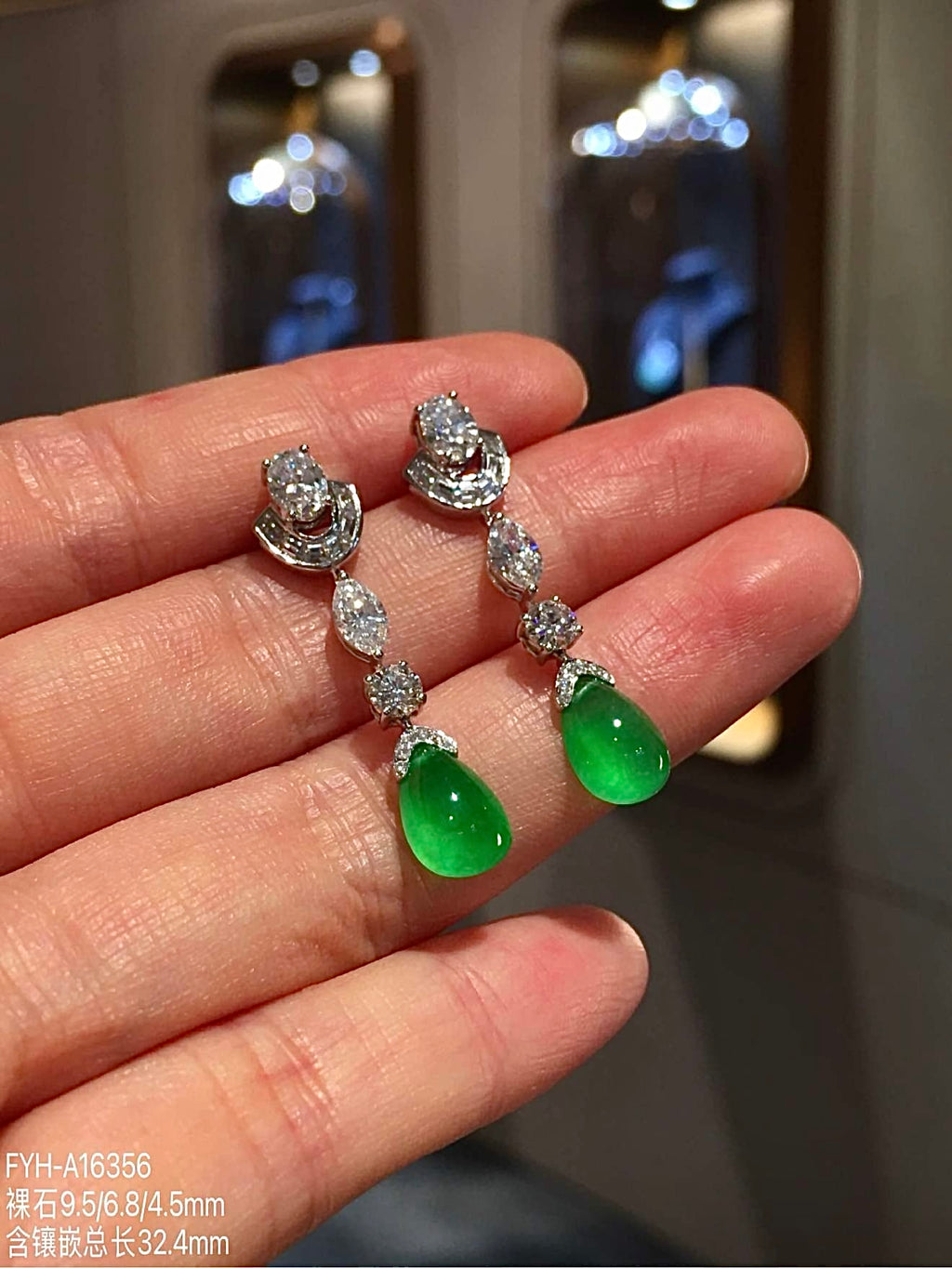 Three-quarter view of vivid green jadeite teardrop earrings with diamond accents