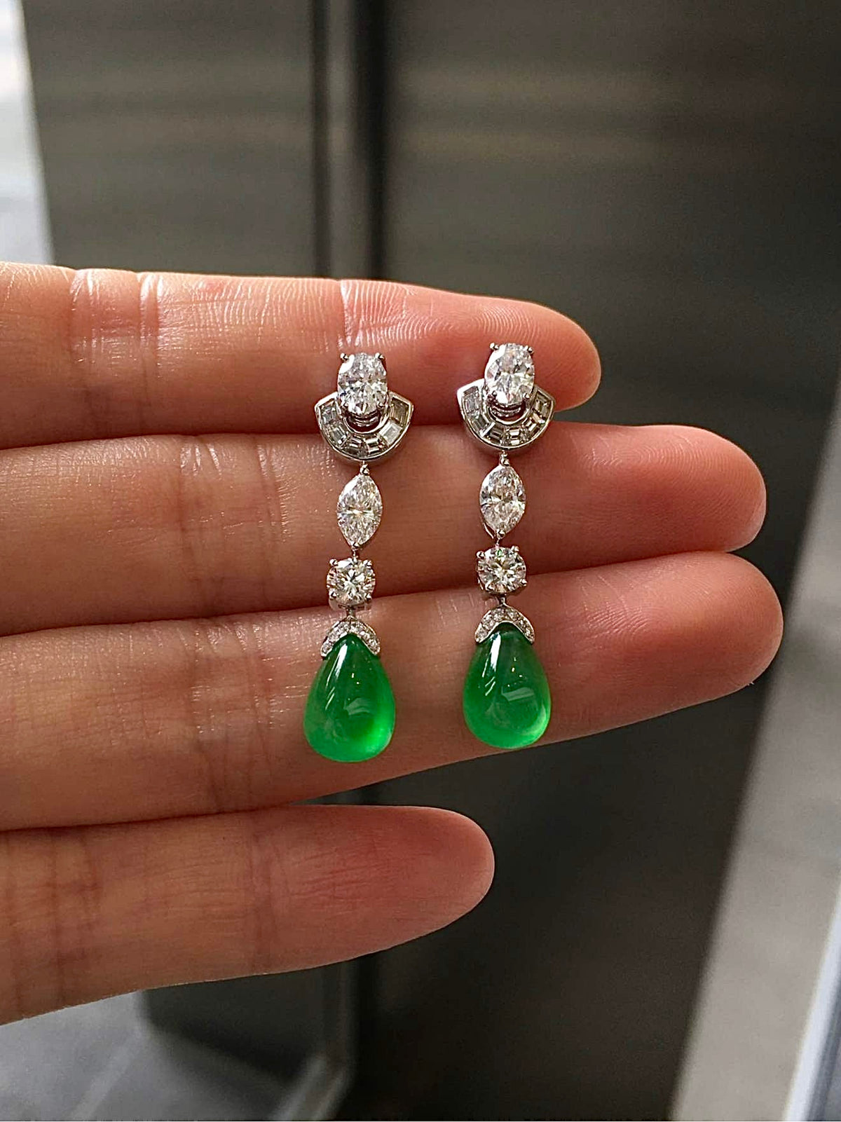 Green jadeite teardrop earrings under neutral lighting