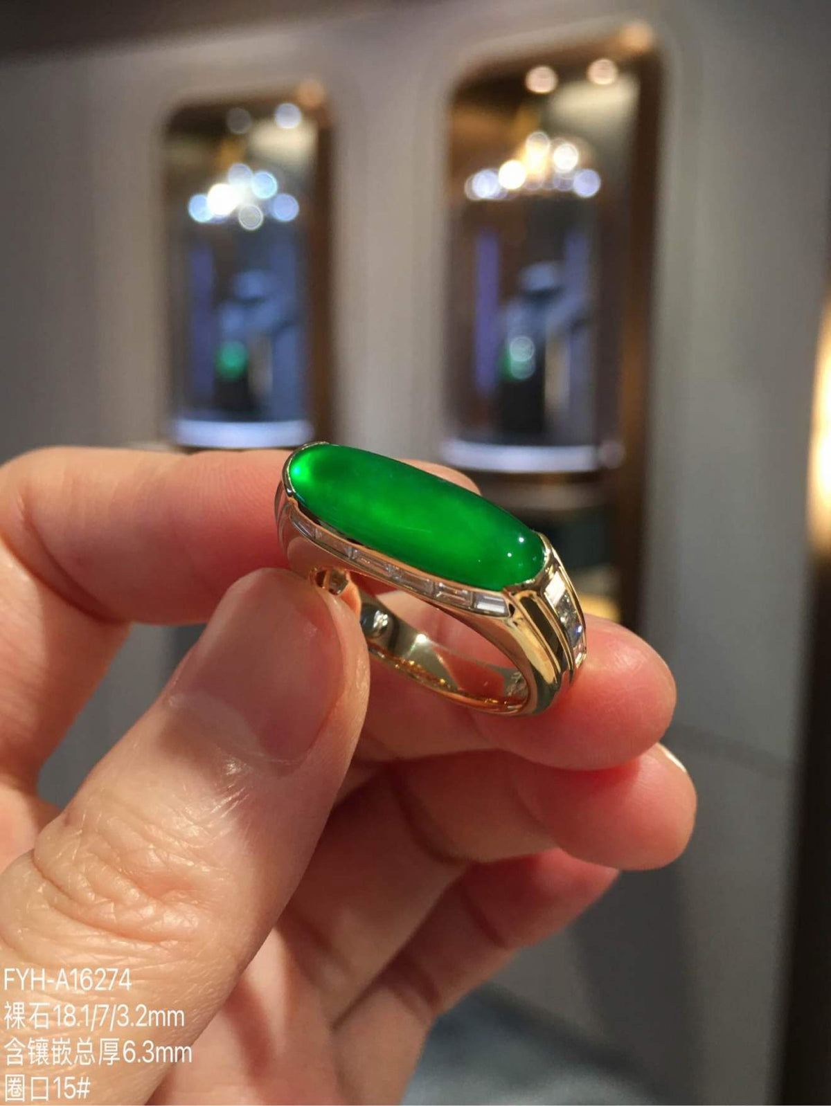 Angled close-up of glass-type imperial green jadeite in an 18K gold diamond-set ring